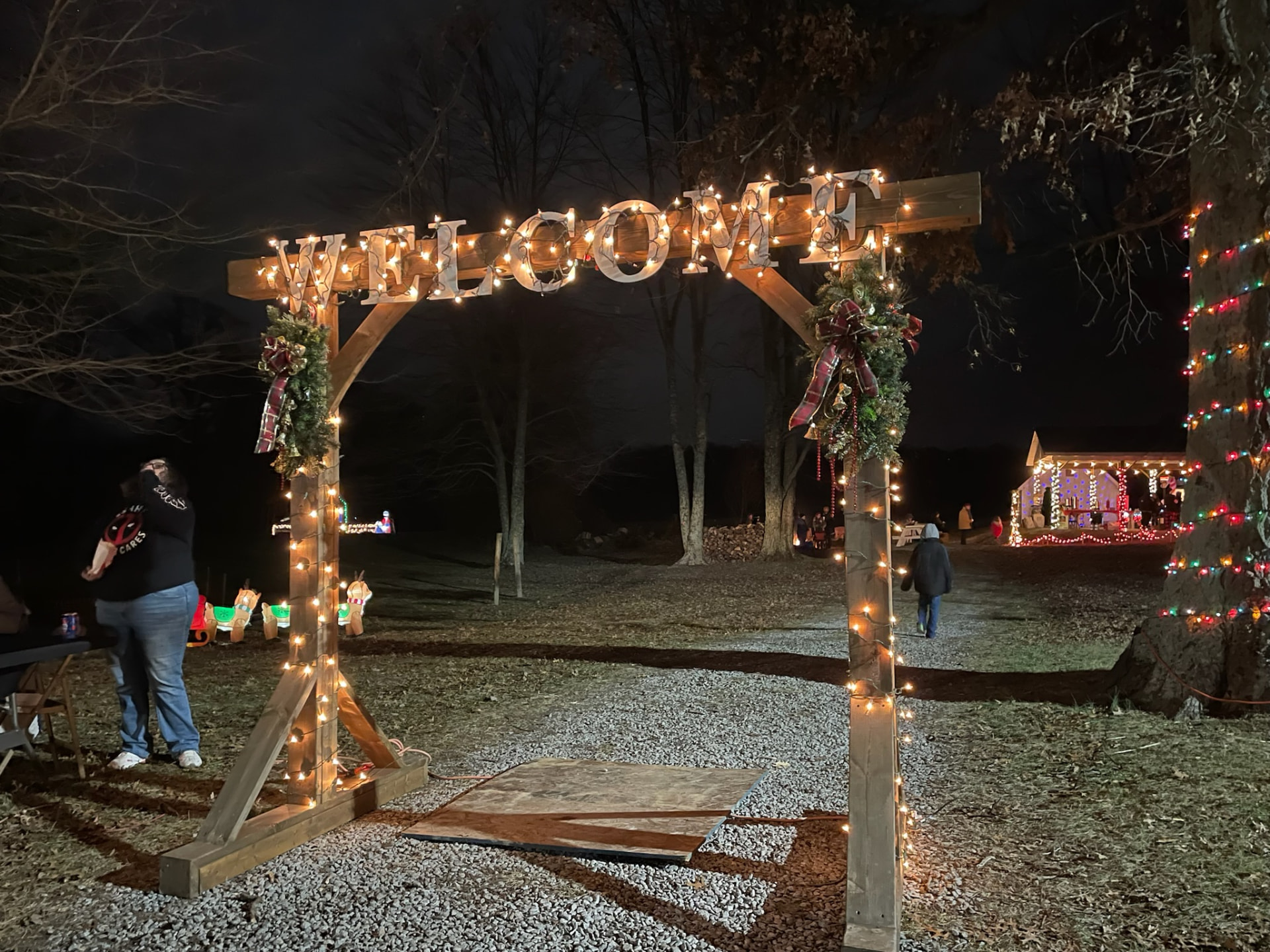 Lit wooden Welcome arch at the entrance to the festival