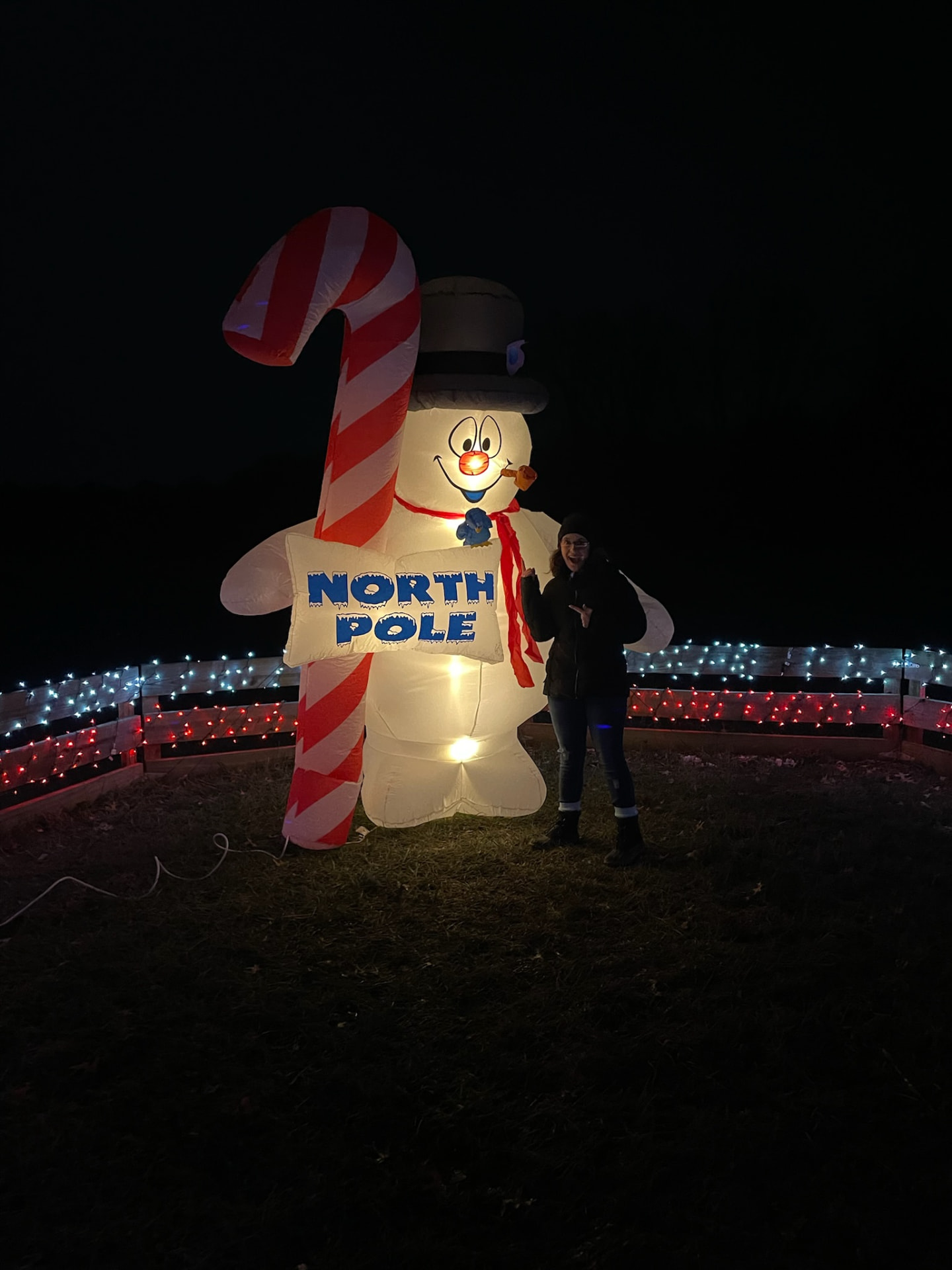 Giant lighted snowman holding a North Pole sign