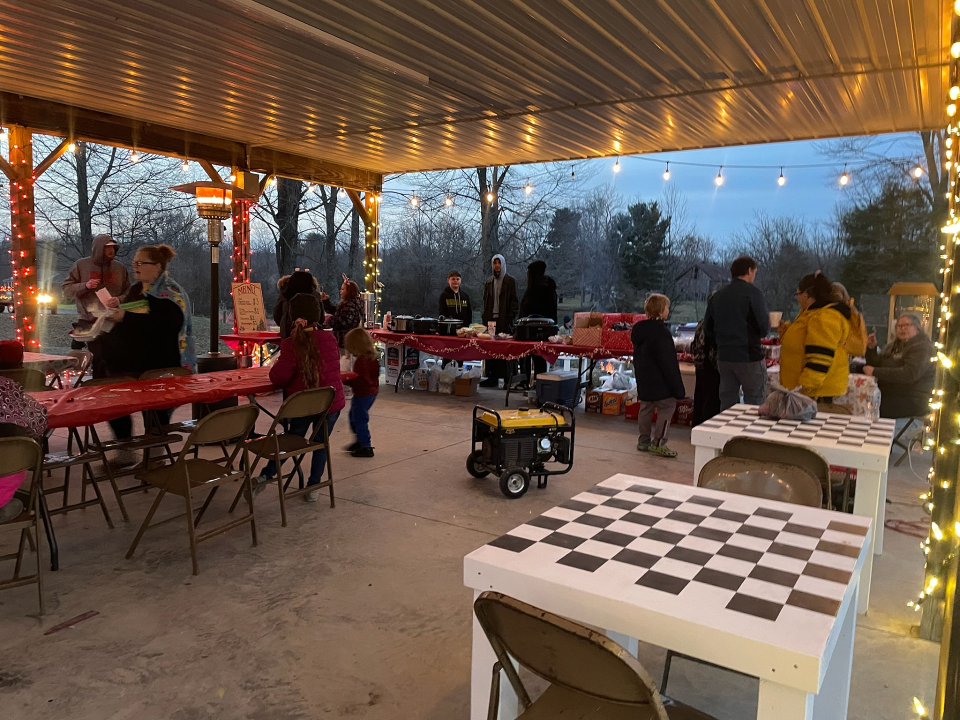 Covered pavilion with string lights, food tables and games